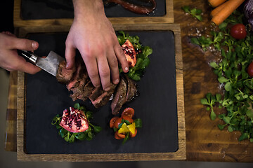 Image showing top view of Chef hands serving beef steak