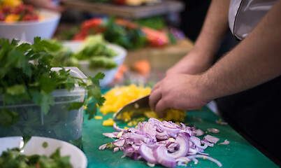 Image showing Chef hands cutting fresh and delicious vegetables