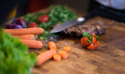 Image showing Juicy slices of grilled steak on wooden board