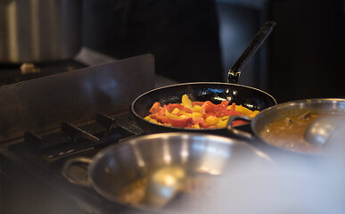 Image showing chef flipping vegetables in wok