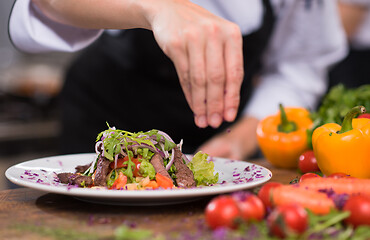 Image showing cook chef decorating garnishing prepared meal