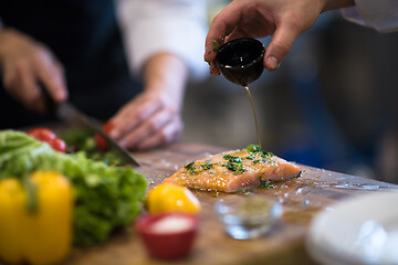 Image showing Chef hands preparing marinated Salmon fish