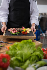 Image showing female Chef holding beef steak plate