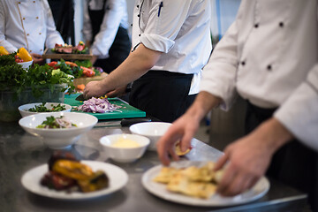 Image showing team cooks and chefs preparing meal