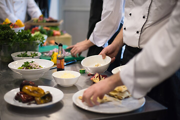 Image showing team cooks and chefs preparing meal