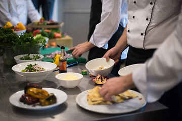 Image showing team cooks and chefs preparing meal