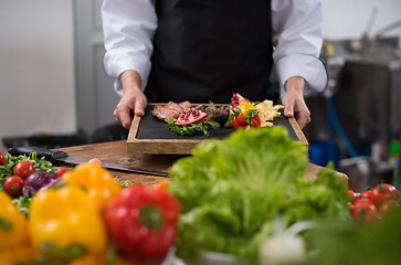 Image showing female Chef holding beef steak plate