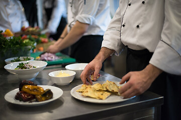 Image showing team cooks and chefs preparing meal