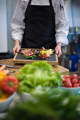 Image showing female Chef holding beef steak plate