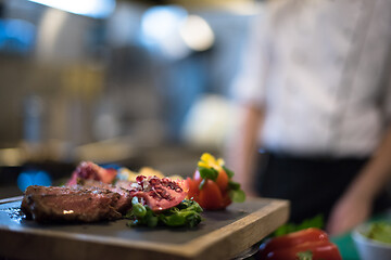 Image showing Juicy slices of grilled steak on wooden board