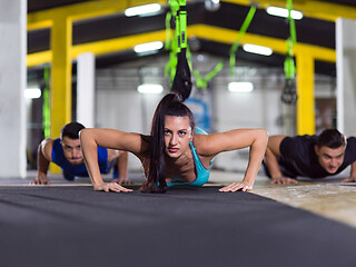 Image showing young healthy people doing pushups