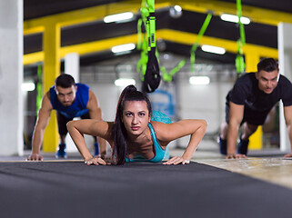 Image showing young healthy people doing pushups