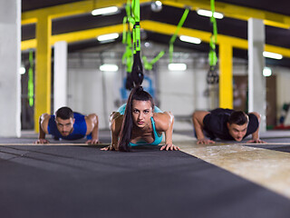 Image showing young healthy people doing pushups