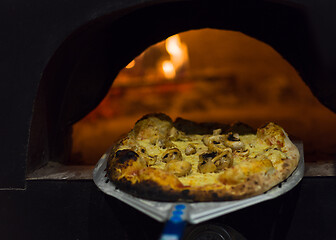 Image showing chef removing hot pizza from stove