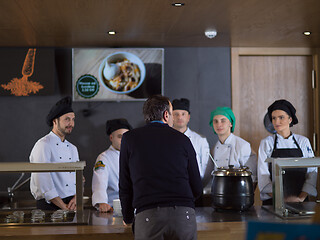 Image showing chefs in the kitchen presenting dish of tasty meal