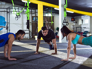 Image showing young healthy people doing pushups