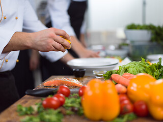 Image showing Chef hands preparing marinated Salmon fish