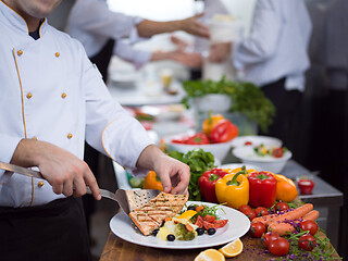 Image showing cook chef decorating garnishing prepared meal