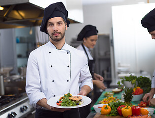 Image showing Chef holding dish of fried Salmon fish fillet