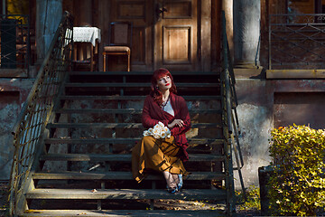 Image showing Girl sitting on old house stairs