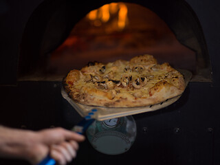 Image showing chef removing hot pizza from stove