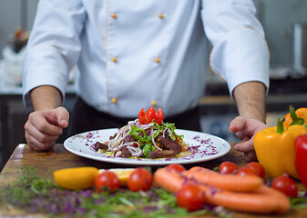 Image showing cook chef decorating garnishing prepared meal