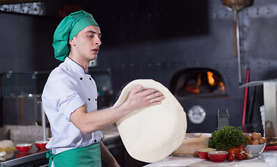 Image showing chef throwing up pizza dough