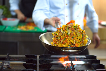 Image showing chef flipping vegetables in wok