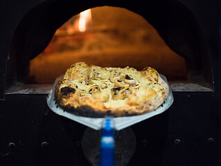 Image showing chef removing hot pizza from stove