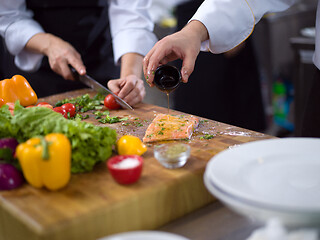 Image showing Chef hands preparing marinated Salmon fish