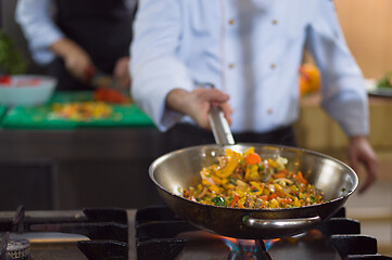 Image showing chef flipping vegetables in wok