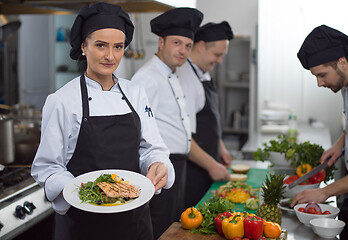 Image showing Chef holding dish of fried Salmon fish fillet