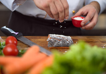 Image showing Chef hands preparing marinated Salmon fish