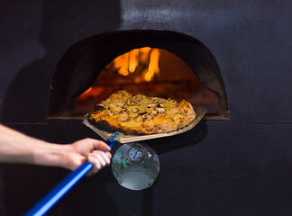 Image showing chef removing hot pizza from stove