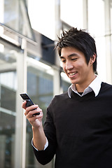 Image showing Texting casual asian businessman