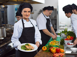 Image showing Chef holding dish of fried Salmon fish fillet