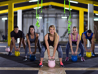 Image showing athletes doing exercises with kettlebells