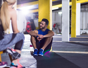 Image showing young athletes sitting on the floor and relaxing