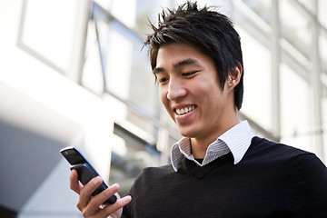 Image showing Casual asian businessman texting