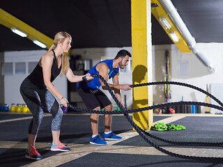 Image showing sports couple doing battle ropes crossfitness exercise