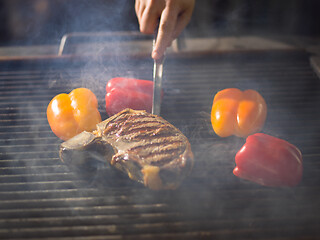 Image showing chef cooking steak with vegetables on a barbecue