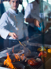 Image showing chef cooking steak with vegetables on a barbecue