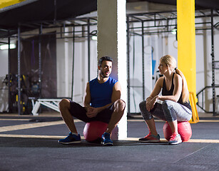 Image showing young athletes sitting on the crossfitness ball and relaxing