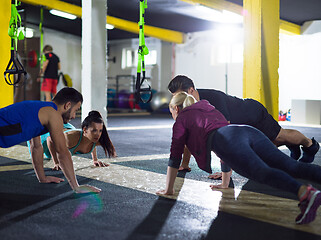 Image showing young healthy people doing pushups