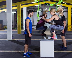 Image showing athletes working out  jumping on fit box