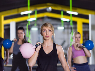 Image showing athletes doing exercises with kettlebells