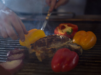 Image showing chef cooking steak with vegetables on a barbecue