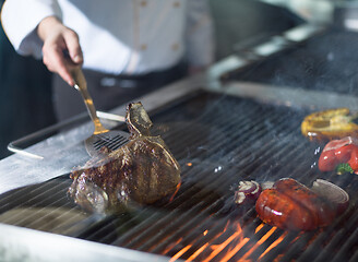 Image showing chef cooking steak with vegetables on a barbecue