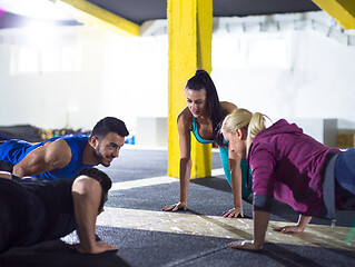 Image showing young healthy people doing pushups