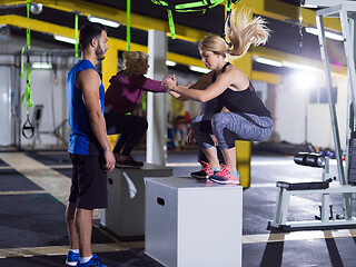 Image showing athletes working out  jumping on fit box